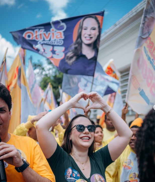 Olívia Tenório em campanha fazendo coração com as mãos
